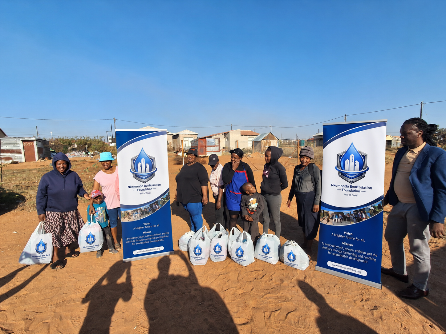 Foundation team posing with distributed support parcels in the community